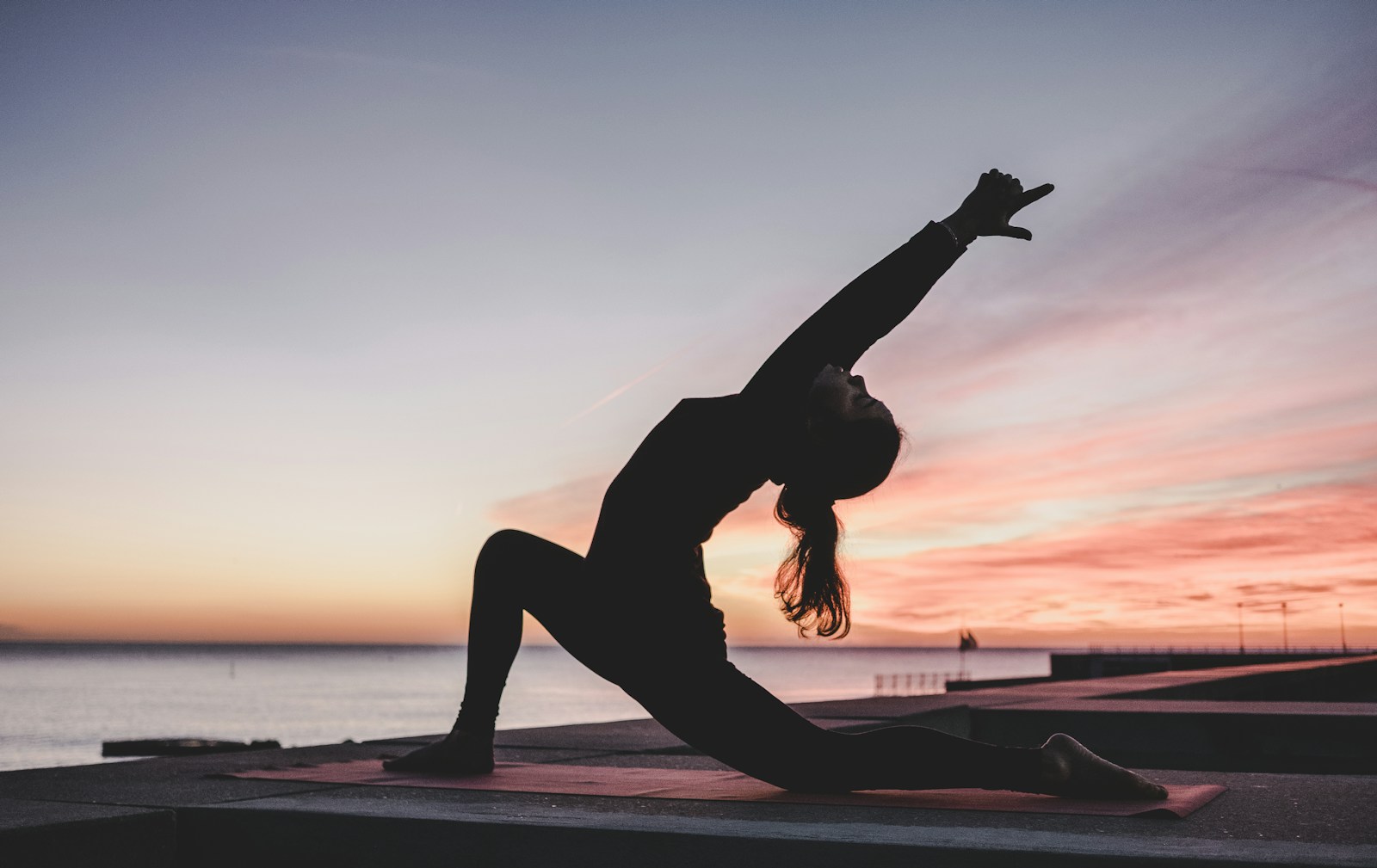 Woman practising a calm yoga stretch in a sunlit studio